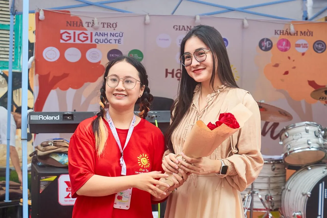 Volunteers in front of the GIGI English sponsor backdrop.