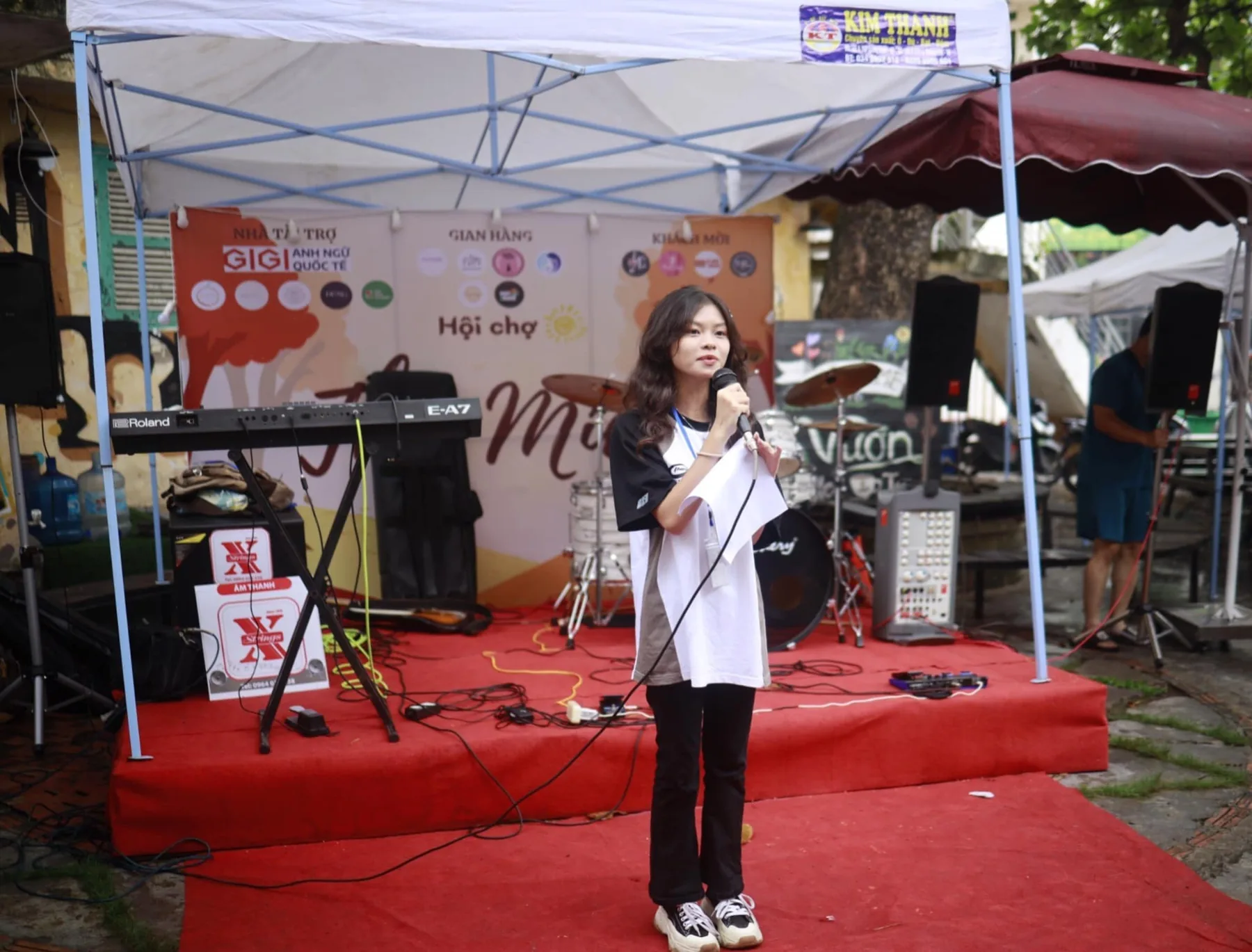A singer performing with the band set up behind her.
