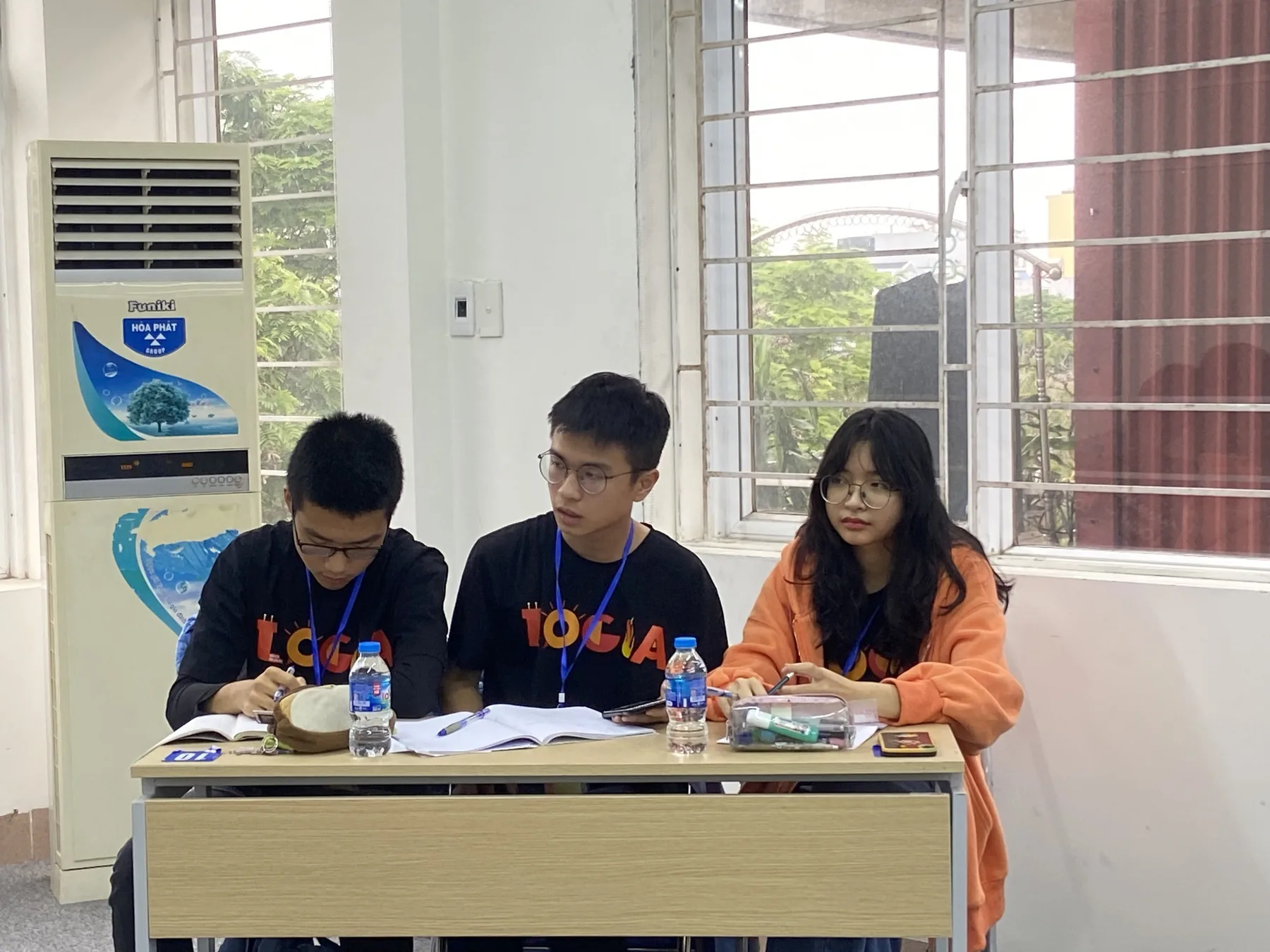 A team at their bench with sponsor-branded materials laid out in front of them.